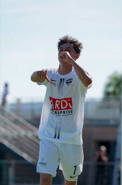 Joueur pointant du doigt en pleine célébration, maillot blanc