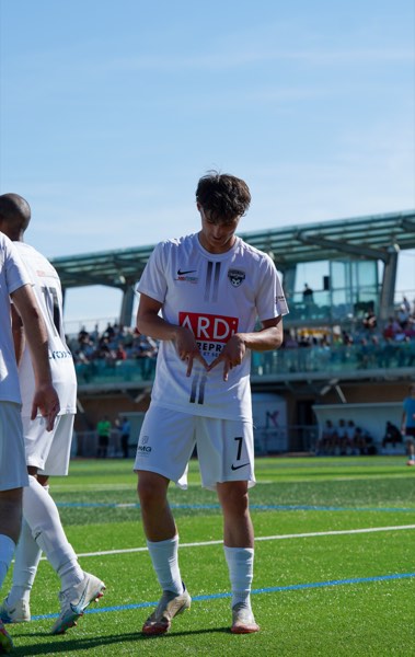 Joueur ajustant son maillot, tribune en arrière-plan
